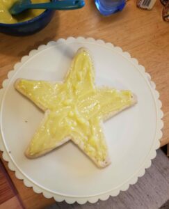 Star-shaped shortbread cookie spread with lime curd, resting on a rotating cake plate.